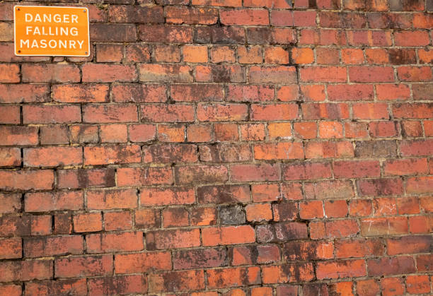 istock Danger Falling Masonry sign on a old red brick building 1303021130