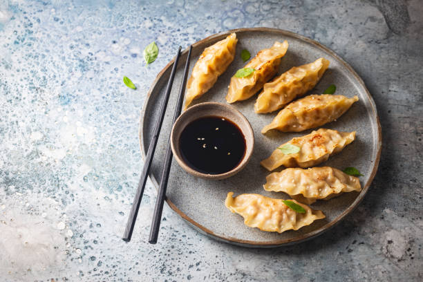 istock Asian dumplings with soy sauce 1303021554