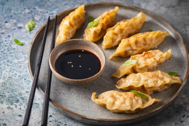 istock Asian dumplings with soy sauce 1303021559