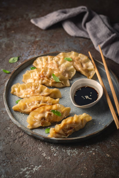 istock Asian dumplings with soy sauce 1303021562