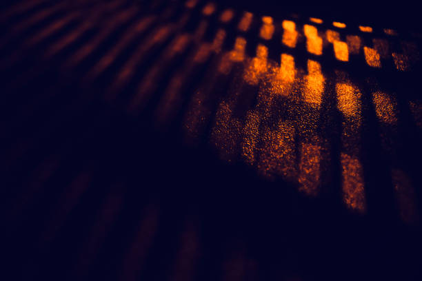 istock Orange lights and black shadows on wooden surface 1303022409