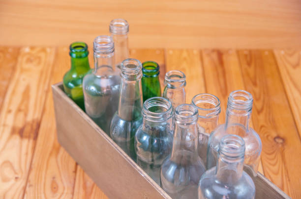 istock Empty glass bottles in a case on wooden board for recycling 1303022626