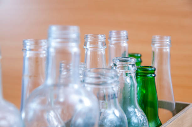 istock Empty glass bottles in a case on wooden board for recycling 1303022627