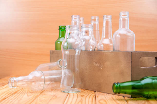 istock Empty glass bottles in a case on wooden board for recycling 1303022678