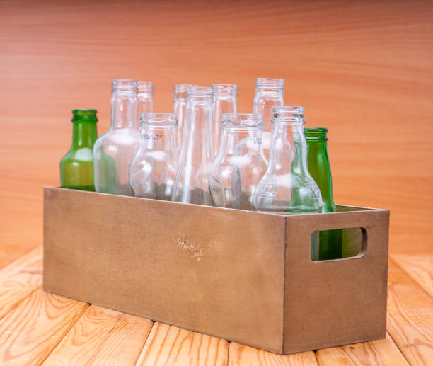 istock Empty glass bottles in a case on wooden board for recycling 1303022684