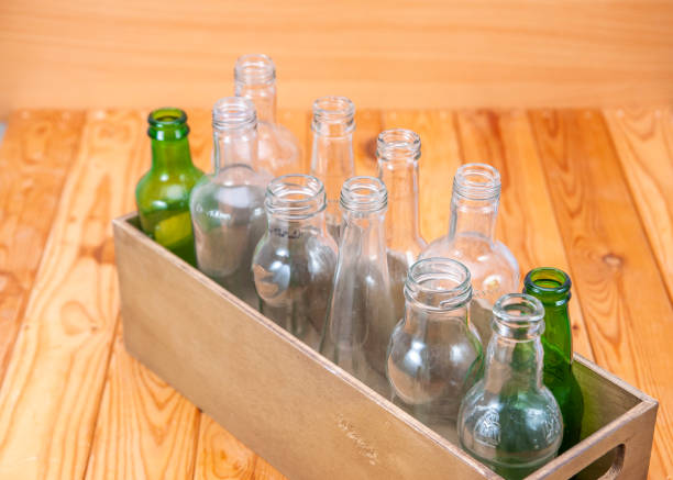 istock Empty glass bottles in a case on wooden board for recycling 1303022694