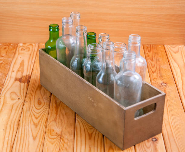 istock Empty glass bottles in a case on wooden board for recycling 1303022709