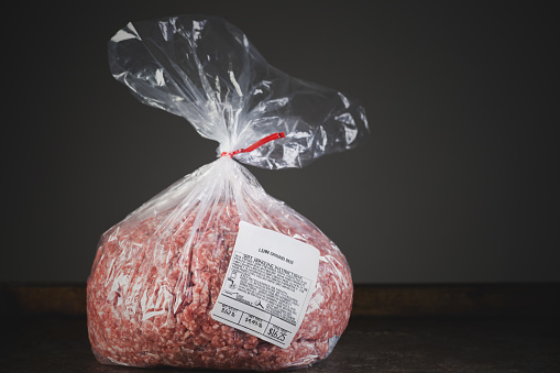 A single package of raw ground beef meat with price tag and safety instructions.