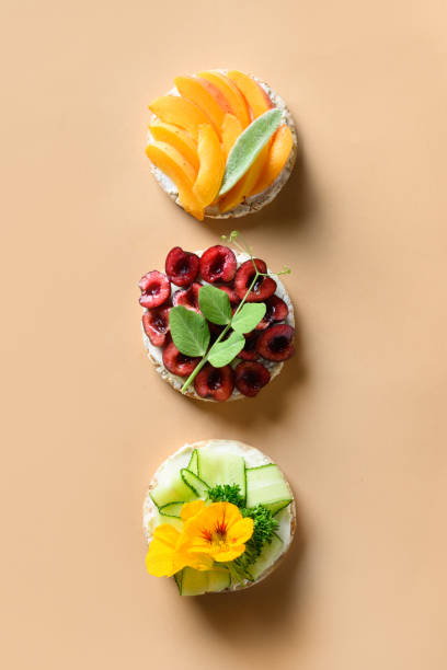 istock Rice cakes with different types garnish fruits, vegetables, microgreens on natural beige background. Banner. 1303028640