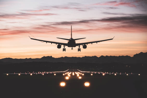 Aircraft landing at sunrise stock photo