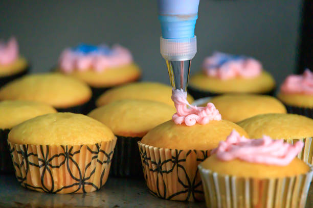 istock Decorating cupcakes with pink and blue frosting 1303031985