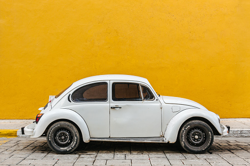 White Volkswagen Beetle parked in a street in Campeche, Mexico.