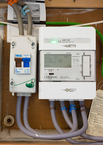 Buckingham, UK - October 23, 2020. Smart electricity meter, EON domestic electric meter and main switch in a home electric box