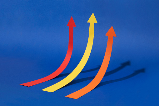 Three arrow head chart lines moving upwards to one direction on blue background.