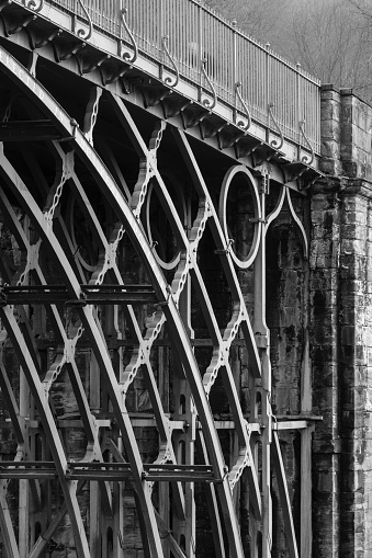 Telford, UK - February 18, 2013. Detail of ironwork on the Iron Bridge, the first cast iron arch bridge built in the industrial revolution. Ironbridge Gorge, Telford, Shropshire, UK. Monochrome image.
