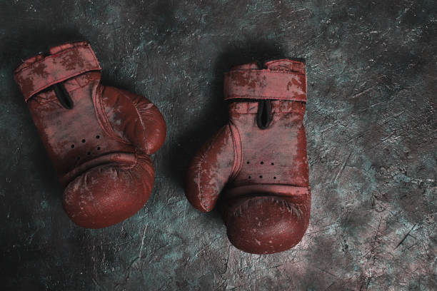 istock Old red Boxing gloves on a concrete background. 1303037192