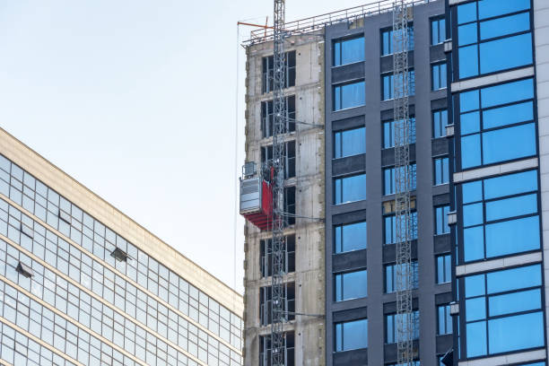 istock Construction elevator outside the facade of a multi-storey building under construction. 1303038586