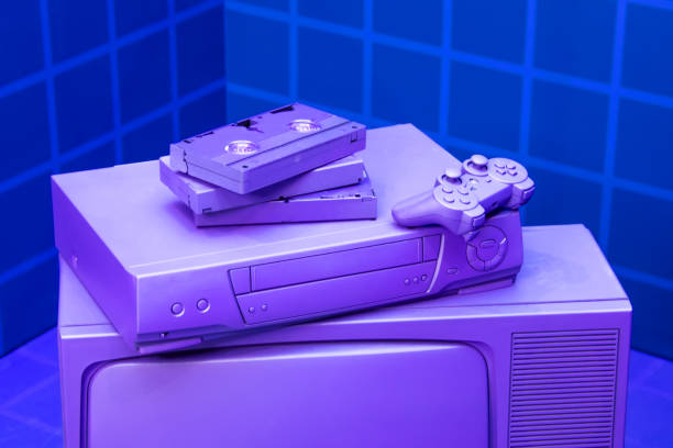 videorekorder für videobänder, ein spiel joystick liegen auf einem violetten, lila vintage-tv. konzept für die rückkehr des lebensstils von jugendlichen und jugendlichen in den 80er und 90er jahren. - gamer video game video computer stock-fotos und bilder
