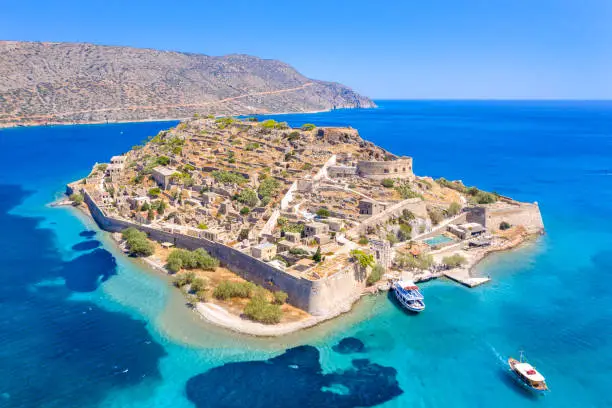 View of the island of Spinalonga with calm sea. Here were isolated lepers, humans with the Hansen's desease, gulf of Elounda, Crete, Greece.