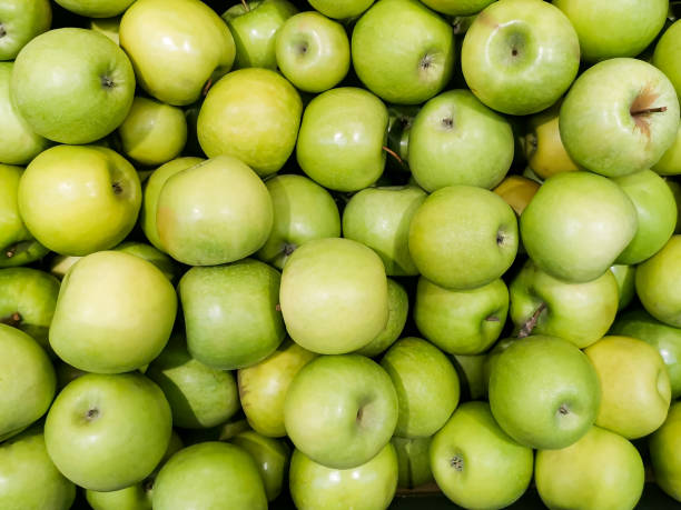istock Solid background of green apples in a crate. Many organic Granny Smith apples. 1303043798