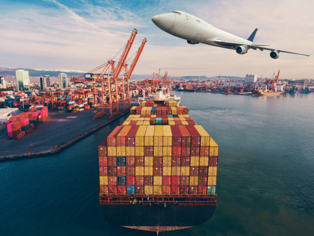 istock Airplane flying above the container ship. Transportation concept. 1303044957