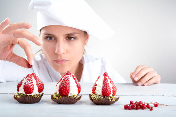 woman cook perfectly decorates small strawberry cupcakes