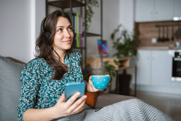 istock Young woman using smart phone at home, relaxing at home. 1303046466