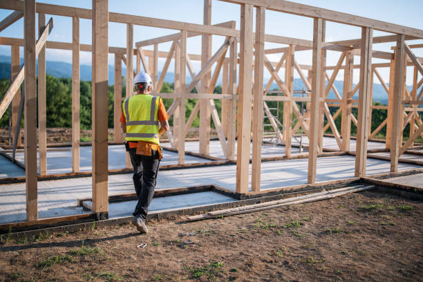 istock Senior builder working on a wooden house. 1303046470