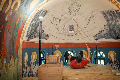 An artist painting frescos in the church.