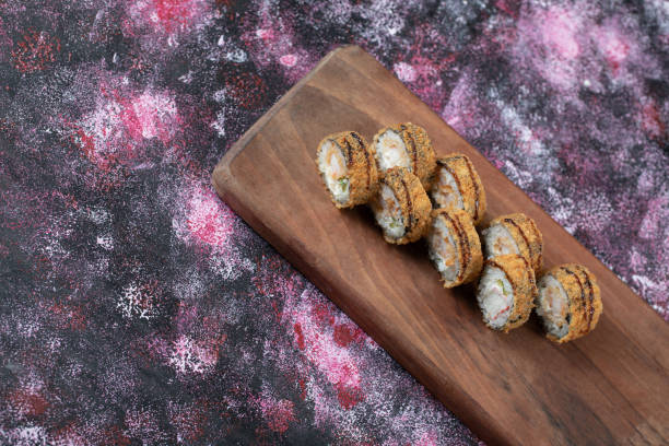 istock Hot sushi rolls on a wooden board 1303048986
