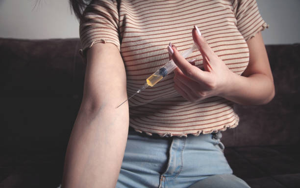 istock Drug addict with a syringe at home. 1303050111