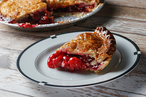 A cherry pie with slice removed to show cherries.