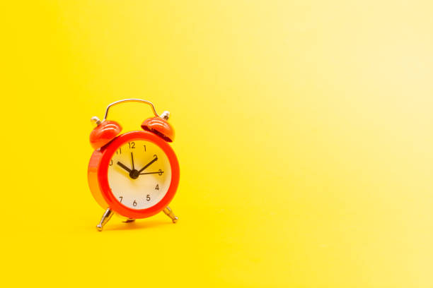 istock red round analog alarm clock isolated on yellow background. time 10:10. space for text. 1303052679