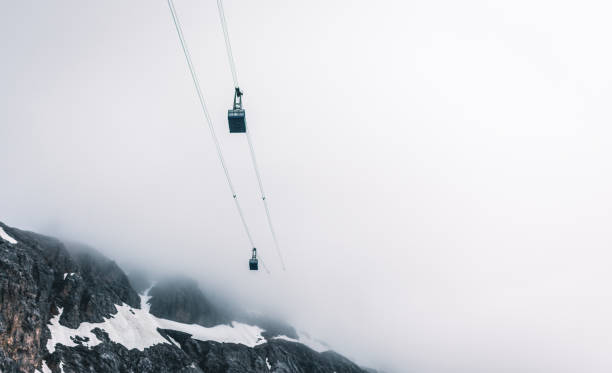 teleférico en las montañas sobre un fondo de nubes. - overhead cable car summer ski lift scenics fotografías e imágenes de stock