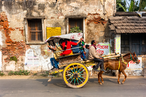 Murshidabad, West Bengal, India - January 2018: A horse cart carrying passengers riding on the streets of the old town of Murshidabad.