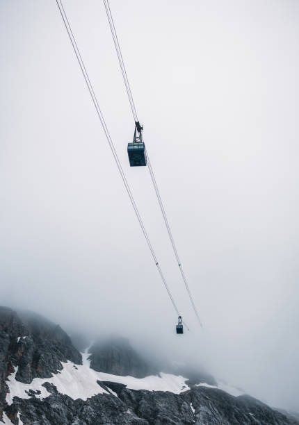 cable car in the mountains against a background of clouds. - overhead cable car dolomites italy snow imagens e fotografias de stock