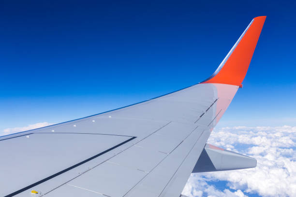 istock Aerial view of cloud blue sky and plane wing view through the airplane window. 1303054792