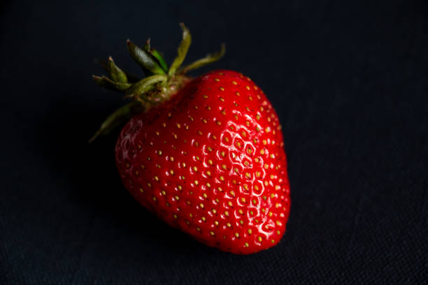 istock One bright strawberry on a black background, appetizing, beautiful, dietary. Place for text, copy space, flat lay 1303056789