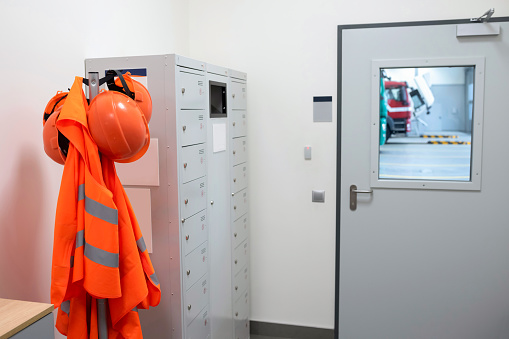 Safety helmets and vests in the technical room of the car service. Safety equipment, car service