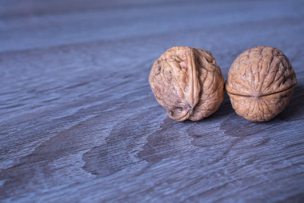 istock Walnuts in a row on a wooden background. Copy space 1303067957