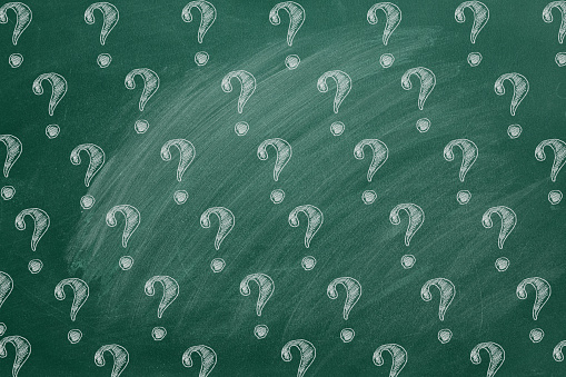 Question marks on blackboard. Ask for help. FAQ concept. Asking questions.
