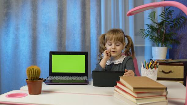 bambino in età prescolare a distanza apprendimento online a casa, ascolto lezione audio, fare i compiti - home schooling audio foto e immagini stock