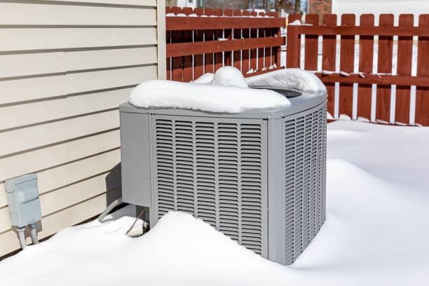 House air conditioning unit covered in snow during winter.. Concept of home air conditioning, hvac, repair, service, winterize and maintenance. stock photo