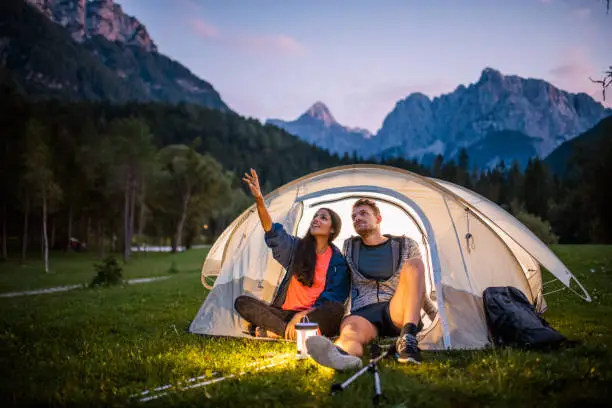 Photo of Slovenian Campers Admiring View from Tent Porch at Dusk