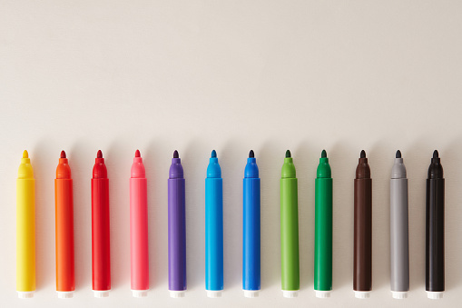 Multi-colored bright felt-tip pens on a white background