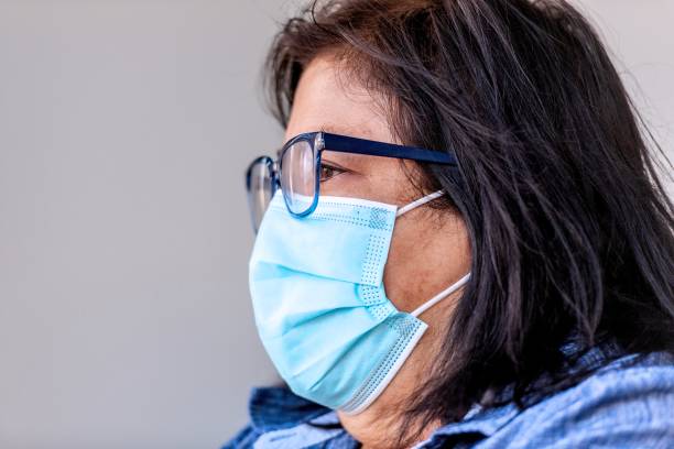 istock Mature senior hispanic woman wearing a protective face mask 1303080156
