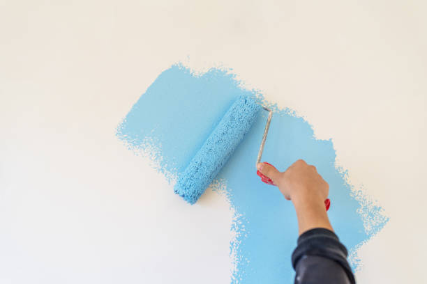 istock Workman painting the wall in blue. 1303084226