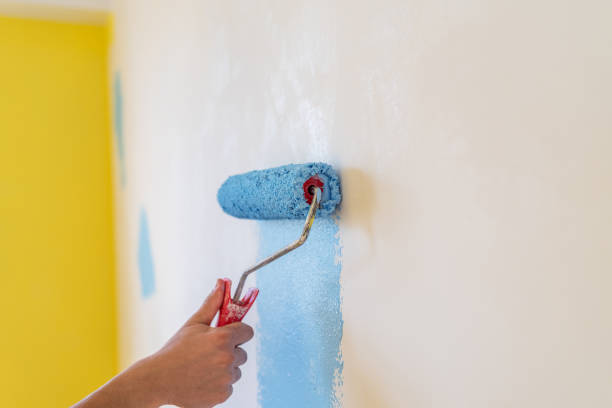 istock Workman painting the wall in blue. 1303084228