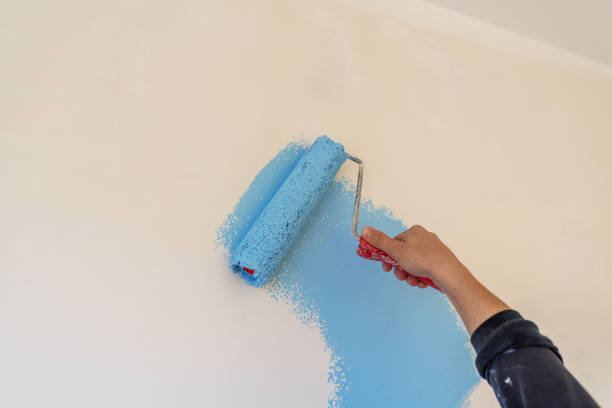obrero pintando la pared en azul. - tinge fotografías e imágenes de stock