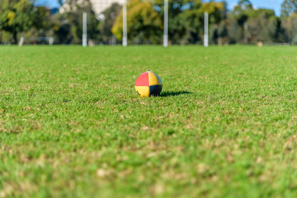 A football sits on the grass with goal posts in the distance A football sits on the grass with goal posts in the distance at a public park in Melbourne, Australia sports training australia stock pictures, royalty-free photos & images